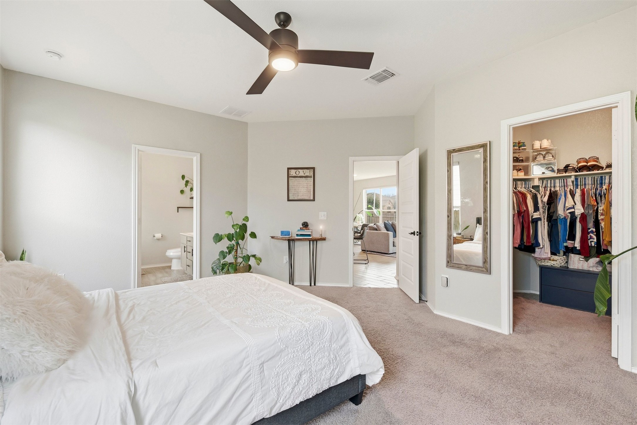 1506 Dragonfly Loop Bastrop, TX 78602 - Photo 13 of 28 Bedroom featuring a spacious closet, light carpet, a ceiling fan, and ensuite bath