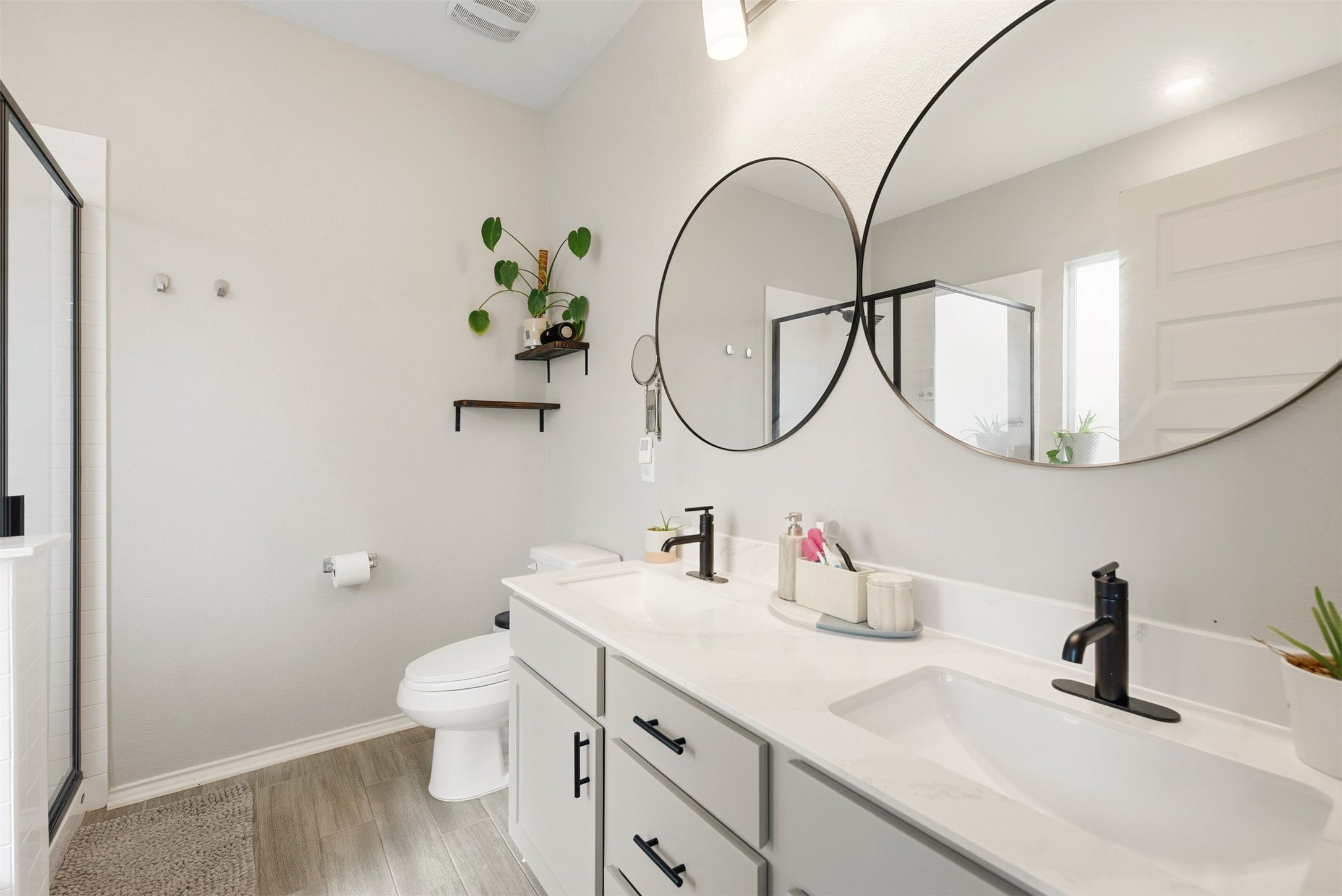 1506 Dragonfly Loop Bastrop, TX 78602 - Photo 14 of 28 Bathroom with a shower stall, double vanity, and light wood-type flooring
