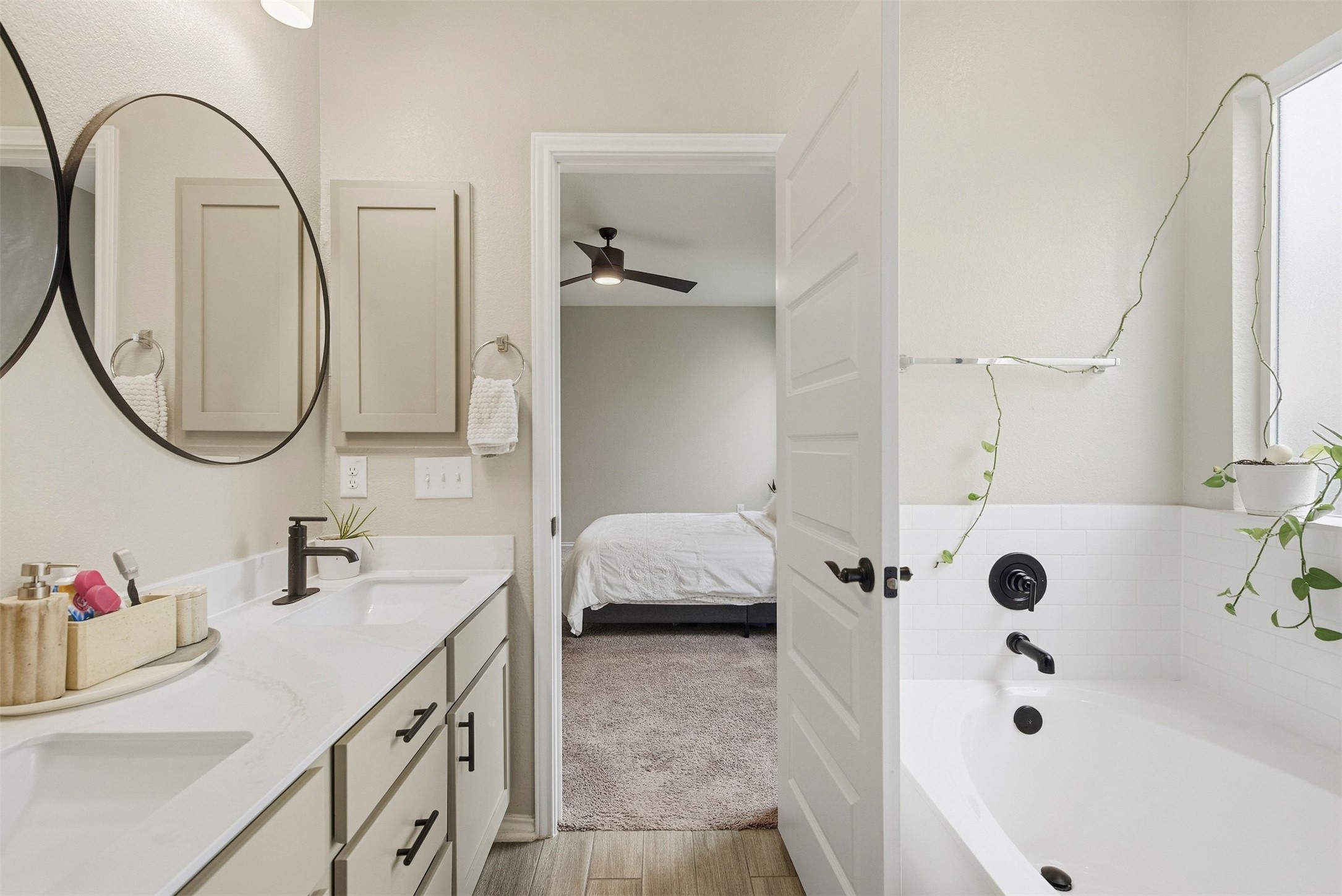 1506 Dragonfly Loop Bastrop, TX 78602 - Photo 15 of 28 Bathroom with a bath, double vanity, ensuite bathroom, light wood finished floors, and a ceiling fan