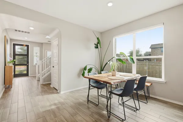 a dining room with furniture and wooden floor