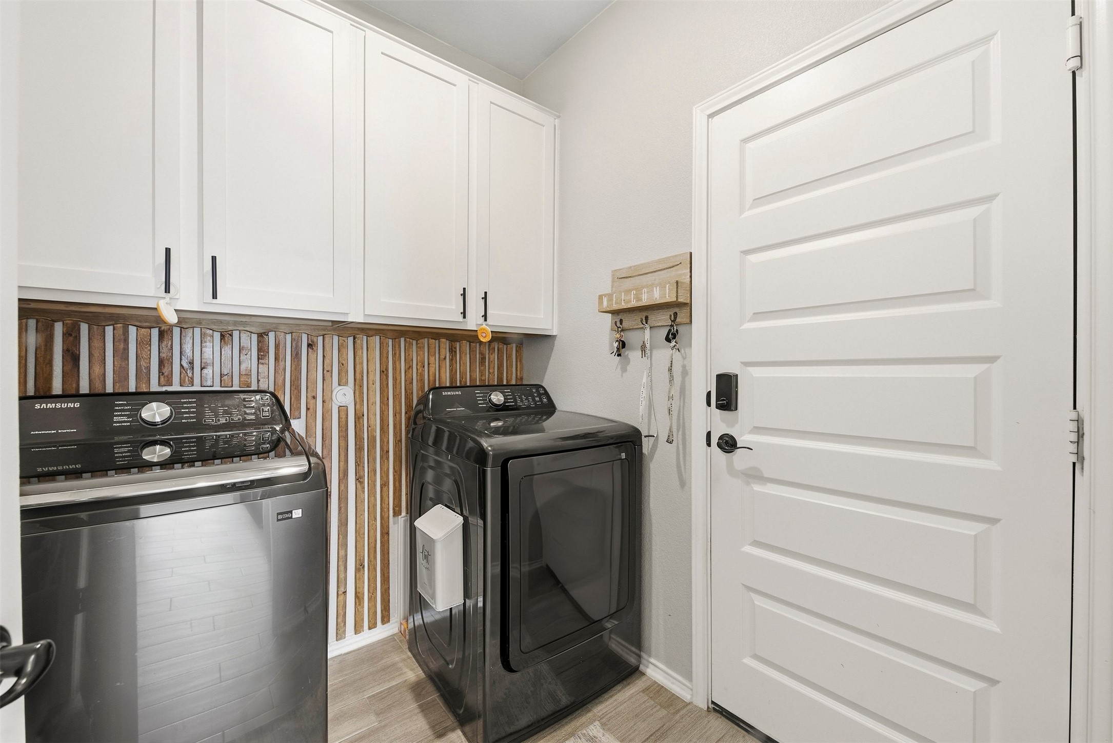 1506 Dragonfly Loop Bastrop, TX 78602 - Photo 25 of 28 Laundry area with cabinet space, light wood-style floors, and separate washer and dryer