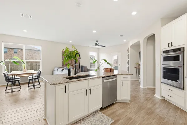 a kitchen with stainless steel appliances kitchen island granite countertop a sink and cabinets
