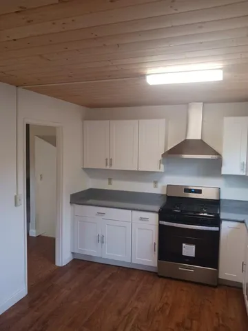 a kitchen with granite countertop a stove and a sink