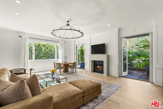 a living room with furniture a fireplace and a floor to ceiling window