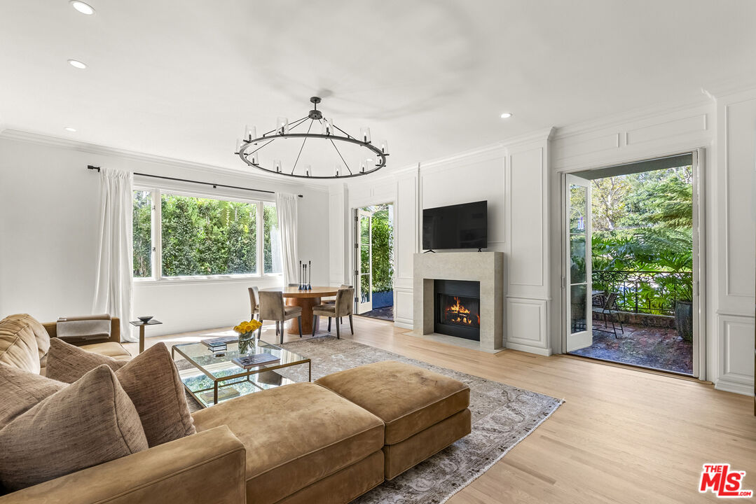 a living room with furniture a fireplace and a floor to ceiling window