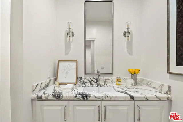 a bathroom with a granite countertop sink and a mirror