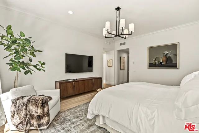 a bedroom with bed tv and couch