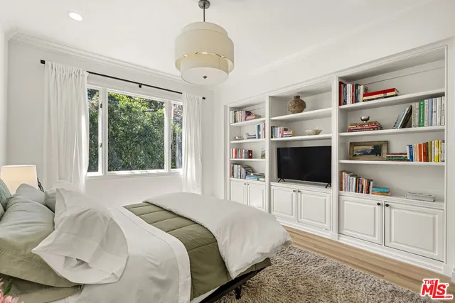 a bedroom with furniture and a flat screen tv