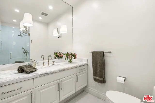 a bathroom with a granite countertop sink mirror and toilet