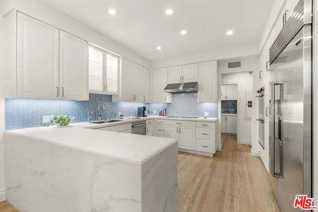 a kitchen with a refrigerator a sink and wooden cabinets