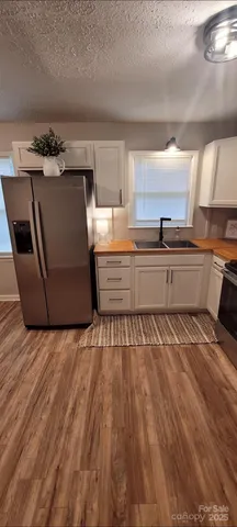 a large kitchen with wooden floor and stainless steel appliances