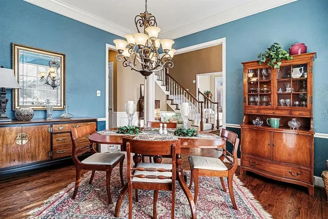 a outdoor dining room with furniture a chandelier and wooden floor