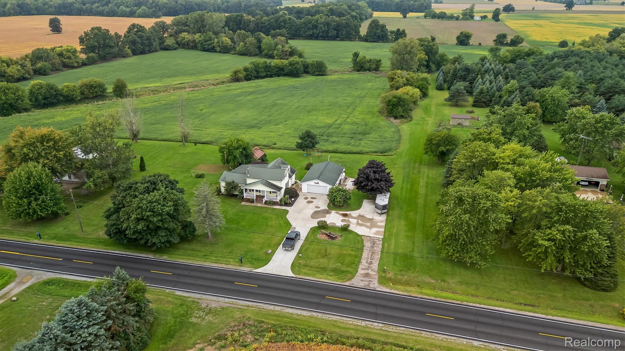 3553 North State Road Owosso, MI 48867 - Photo 43 of 45 Expansive green landscape with a private residence, detached garage, and concrete driveway