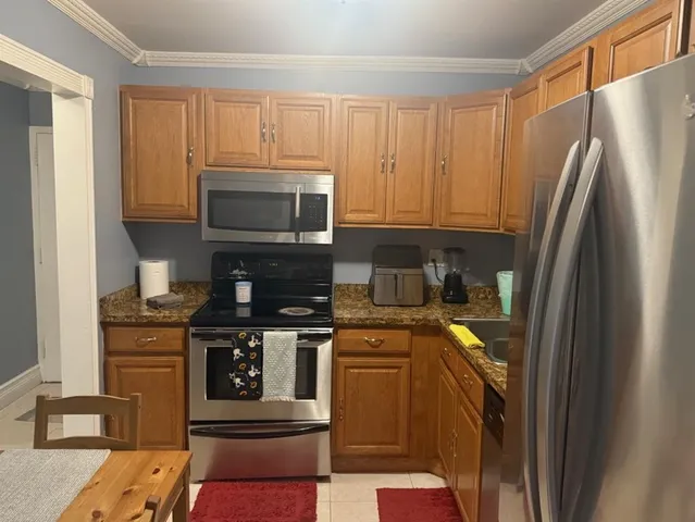 a kitchen with stainless steel appliances granite countertop a stove a refrigerator and a microwave