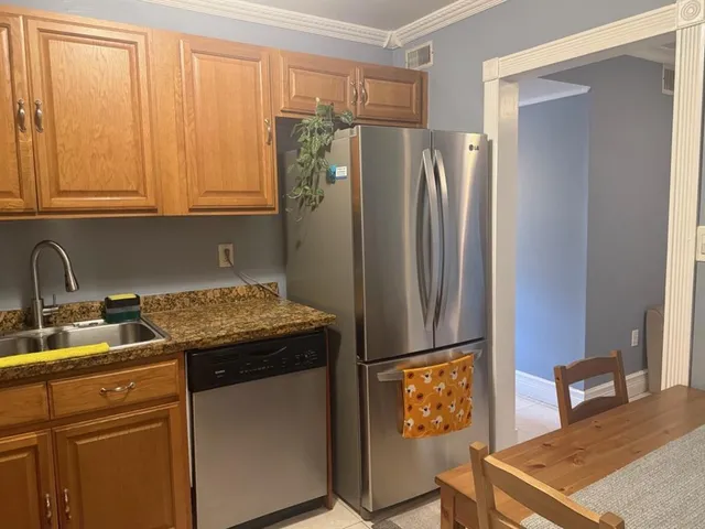 a kitchen with stainless steel appliances granite countertop a refrigerator and a sink