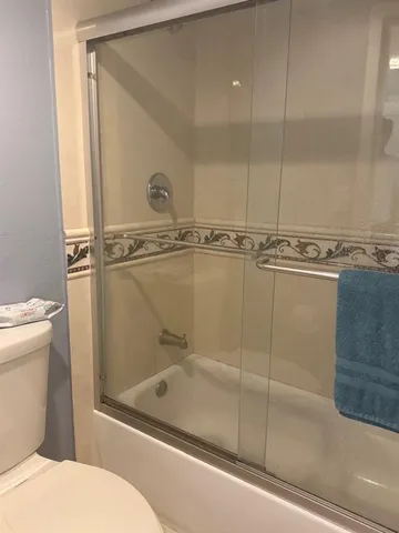 a bathroom with a granite countertop sink mirror vanity and toilet
