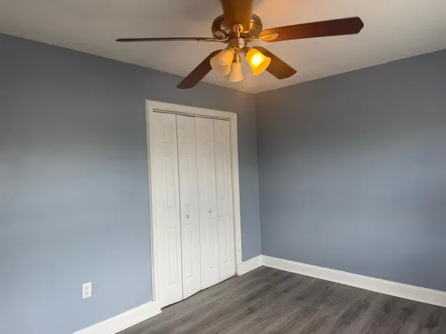 a view of a bedroom with a bed and wooden floor