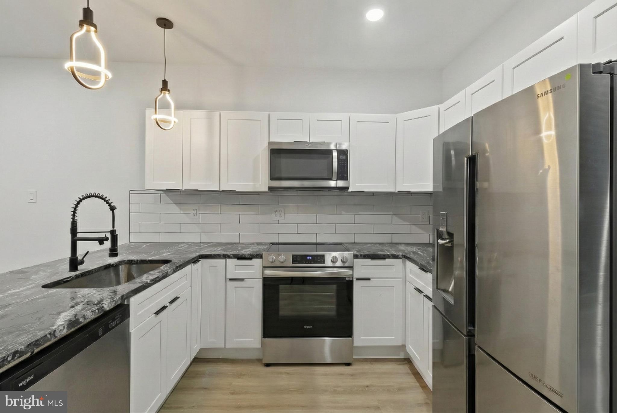 5214 Jefferson Street Philadelphia, PA 19131 - Photo 12 of 28 a kitchen with stainless steel appliances granite countertop a stove a sink and a refrigerator