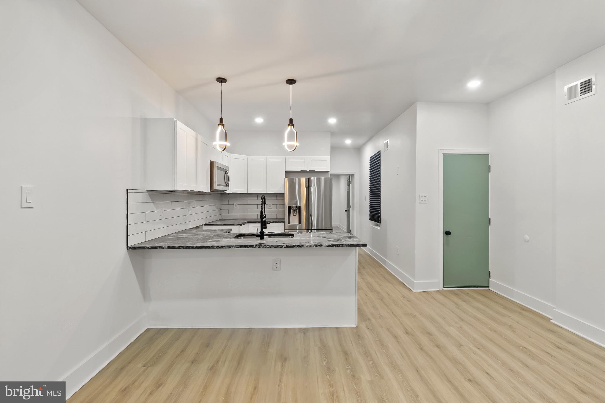 5214 Jefferson Street Philadelphia, PA 19131 - Photo 9 of 28 a large kitchen with stainless steel appliances a large counter top a sink and a wooden floors