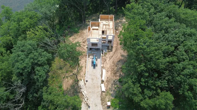 a aerial view of a house with a yard and large trees