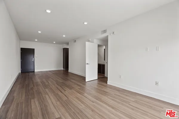 a view of an empty room with wooden floor