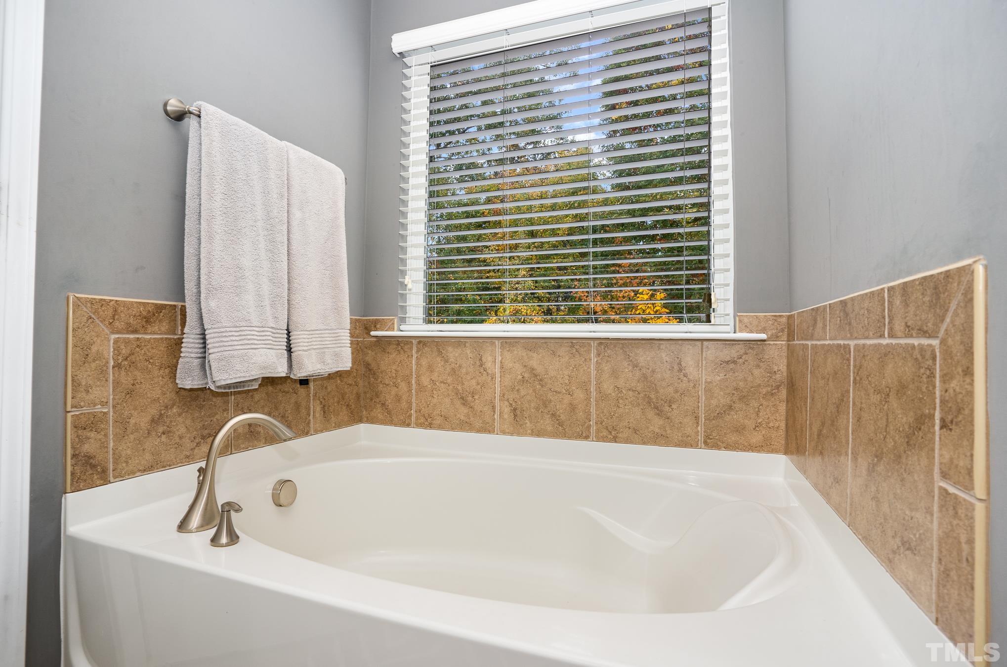 3608 Althorp Drive Raleigh, NC 27616 - Photo 16 of 25 a bathroom with a bathtub and a window