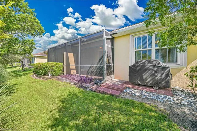 a sign board with flower plants and wooden fence