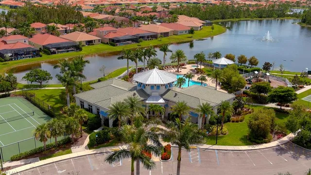 a view of a house with a yard and palm trees