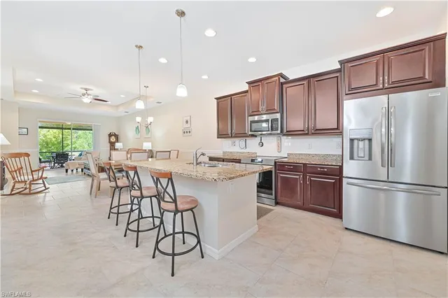 a kitchen with stainless steel appliances granite countertop a stove a sink cabinets and a refrigerator