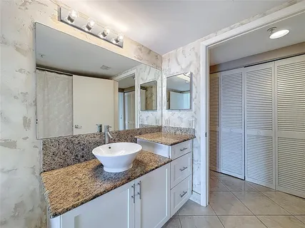 a bathroom with a granite countertop sink a toilet and a mirror