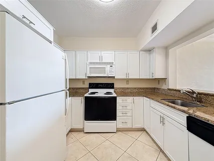 a kitchen with stainless steel appliances granite countertop white refrigerator stove a sink and dishwasher