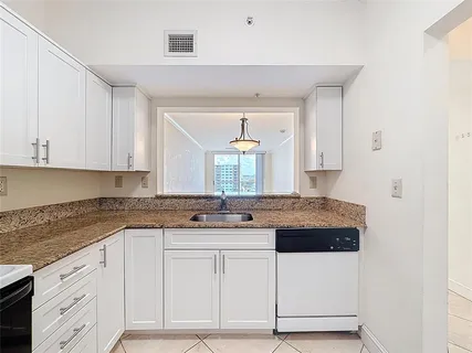 a kitchen with granite countertop a sink and cabinets