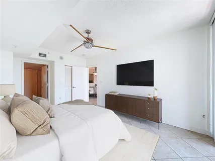 a bedroom with a bed and a flat screen tv