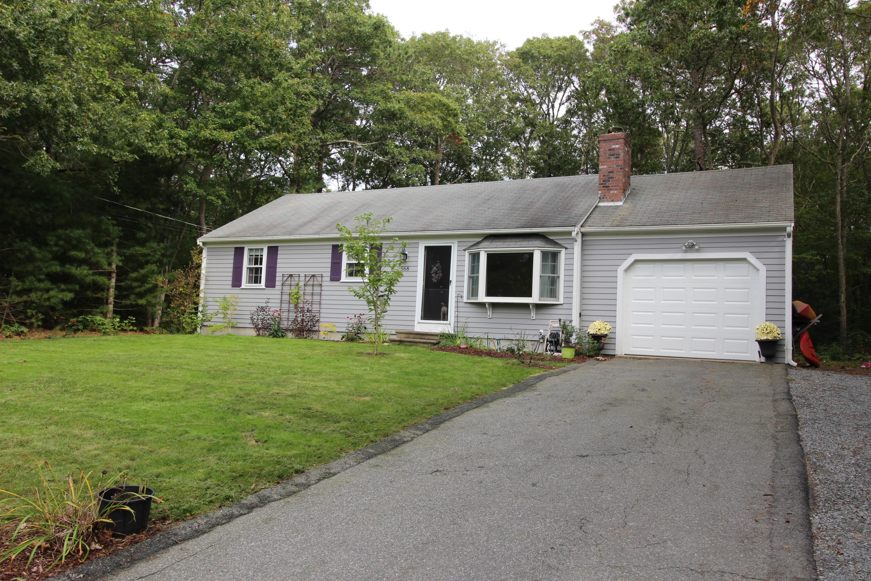 568 Skunknet Road Centerville, MA 02632 - Photo 1 of 18 a front view of a house with a garden and yard