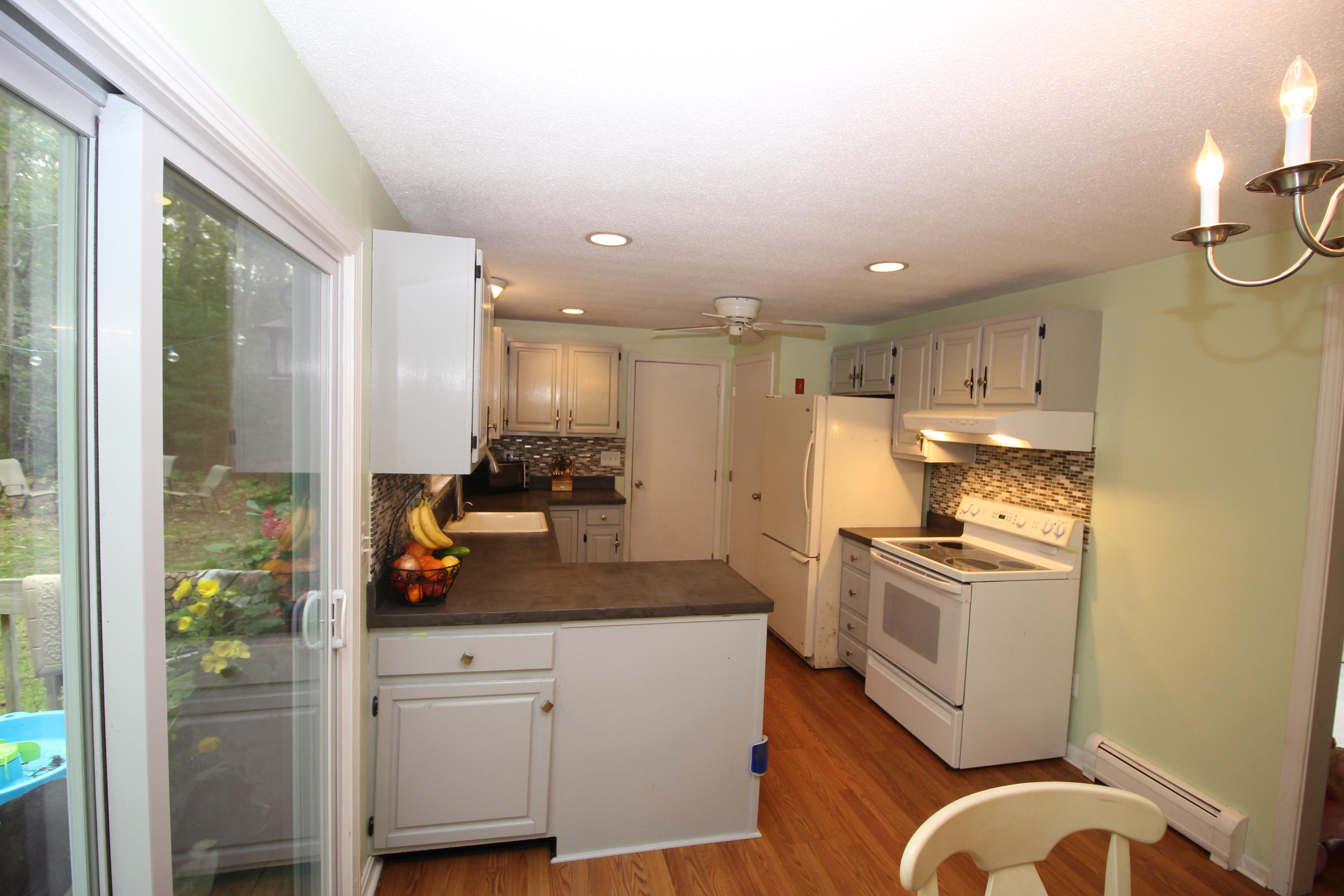 568 Skunknet Road Centerville, MA 02632 - Photo 11 of 18 a kitchen with stainless steel appliances granite countertop a stove a refrigerator and a granite counter tops with white cabinets
