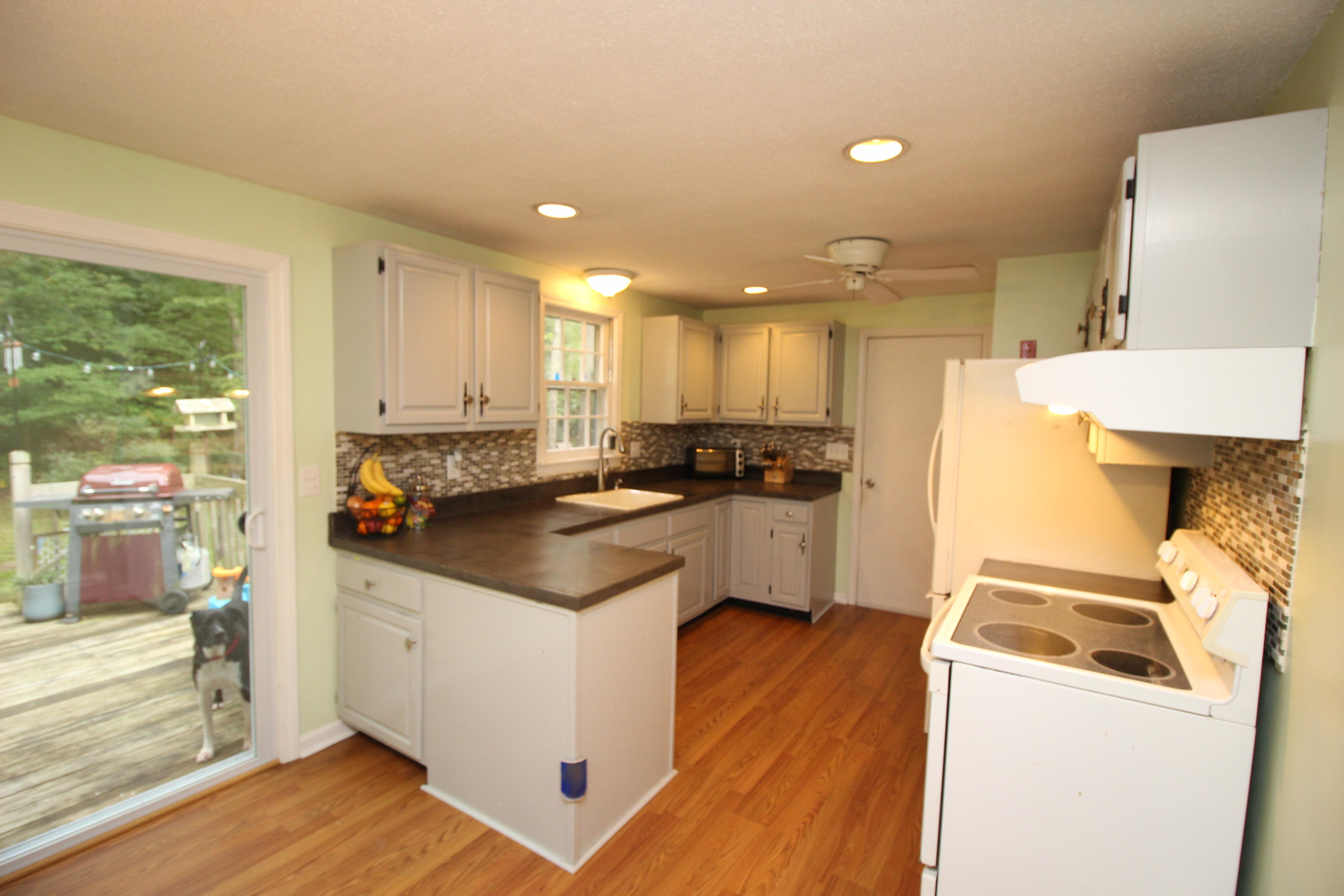568 Skunknet Road Centerville, MA 02632 - Photo 8 of 18 a kitchen with a sink a stove top oven a refrigerator and white cabinets