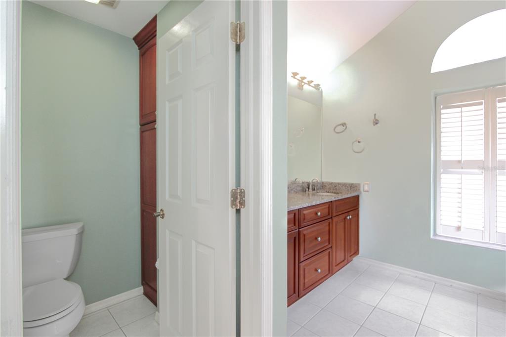 2319 Sunview Avenue Valrico, FL 33596 - Photo 16 of 41 a bathroom with a granite countertop toilet a sink and a mirror