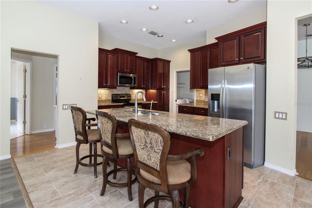 2319 Sunview Avenue Valrico, FL 33596 - Photo 22 of 41 a kitchen with stainless steel appliances granite countertop a table chairs a refrigerator and a sink