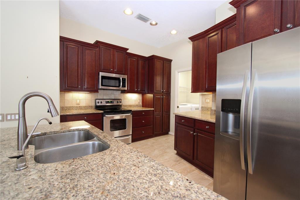 2319 Sunview Avenue Valrico, FL 33596 - Photo 23 of 41 a kitchen with stainless steel appliances granite countertop a refrigerator a stove a sink and a microwave