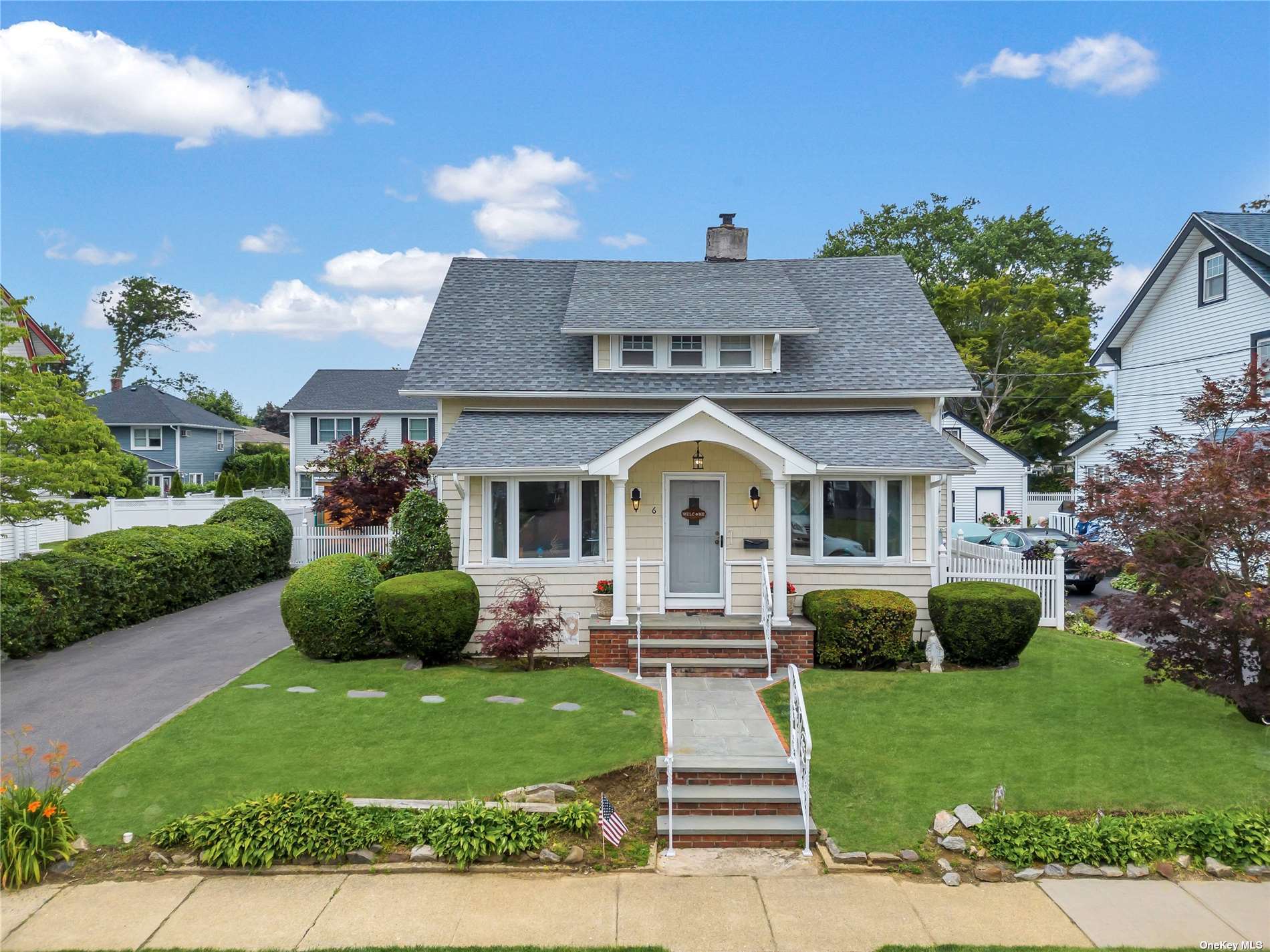 a front view of a house with a garden and plants