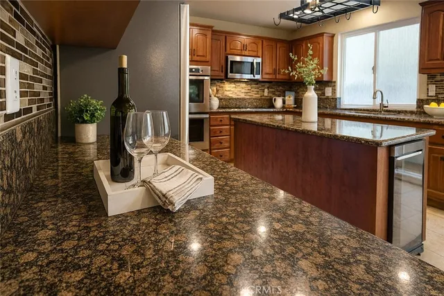 a kitchen with stainless steel appliances kitchen island granite countertop a sink and cabinets