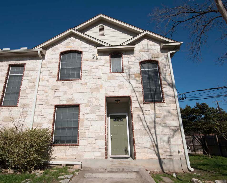 a front view of a house with plants