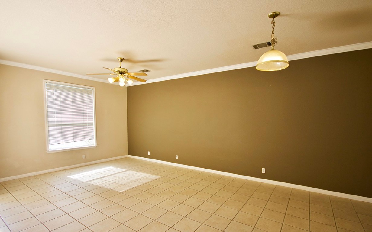 600 Kawnee Drive, Unit D Austin, TX 78752 - Photo 3 of 12 Spare room with crown molding, light tile patterned floors, and a ceiling fan