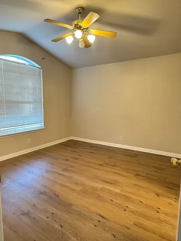 a view of a room with wooden floor and a ceiling fan