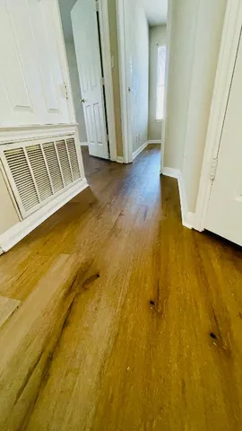 a view of an empty room with wooden floor