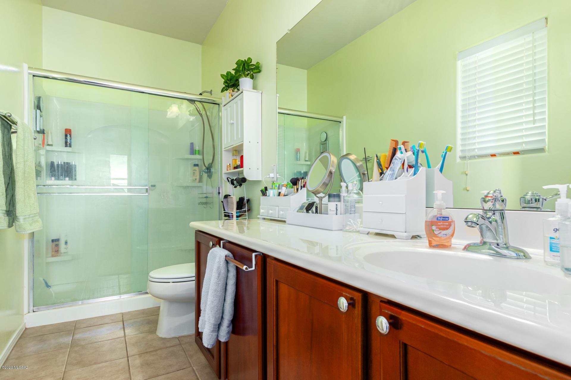 21203 East Reunion Road Red Rock, AZ 85145 - Photo 22 of 26 a bathroom with a granite countertop sink a toilet a mirror and shower
