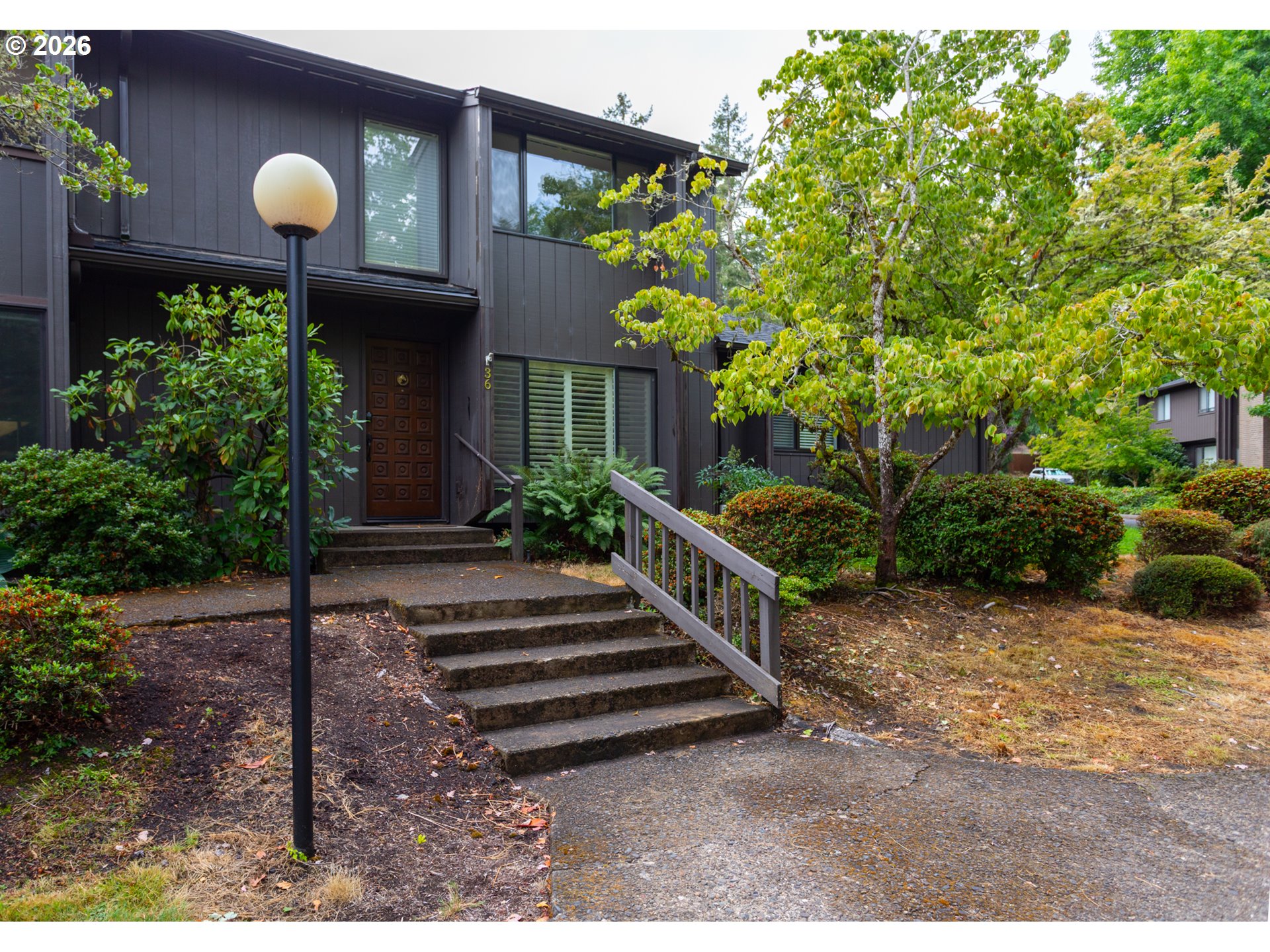 a front view of a house with a yard and potted plants