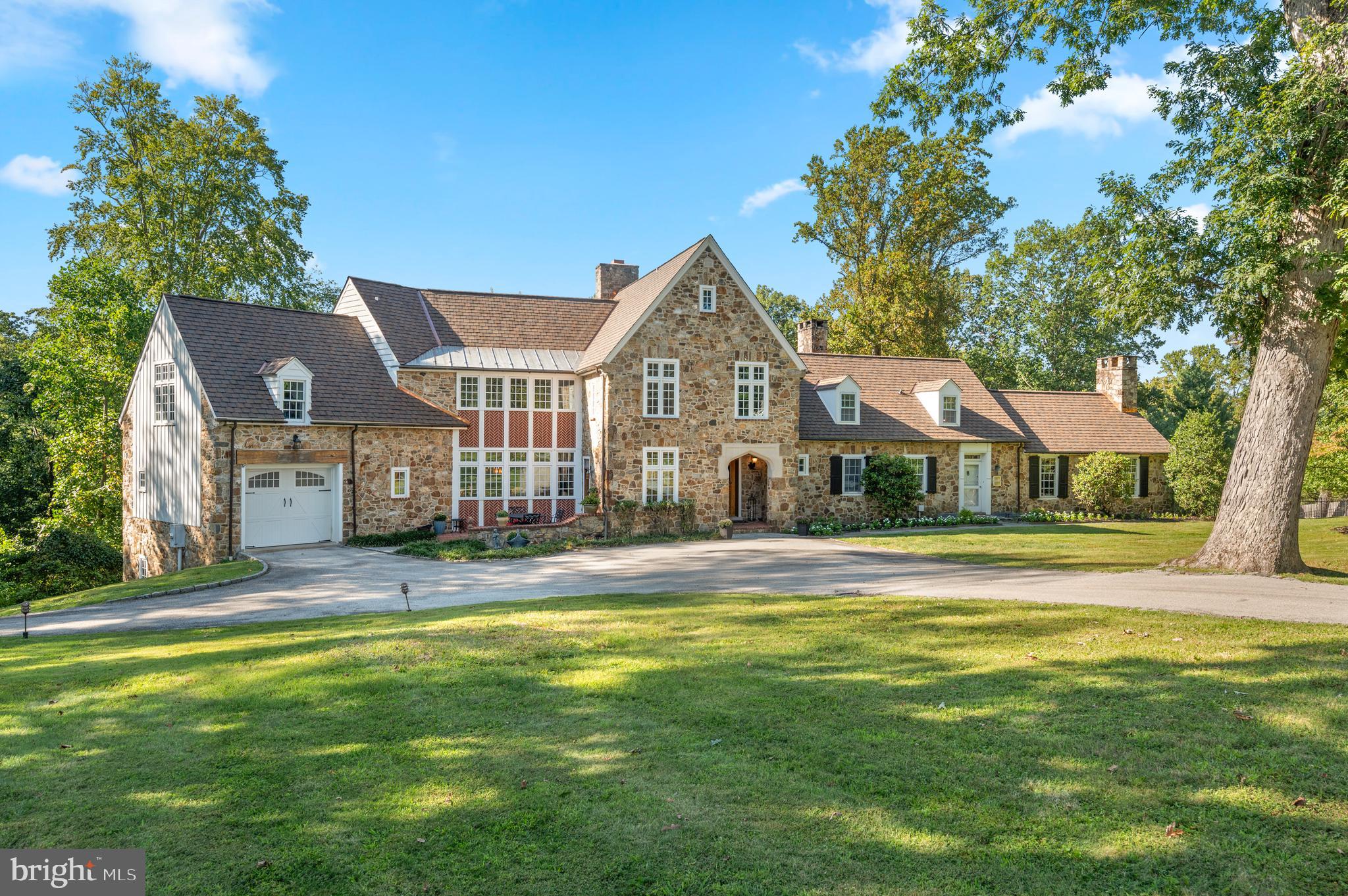 a view of a house with a big yard and large trees