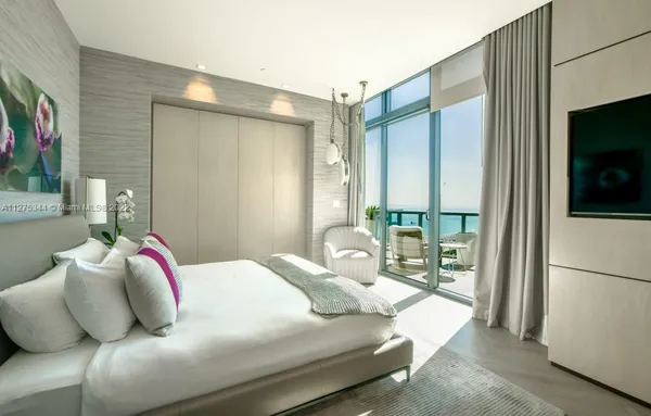 a bedroom with a large bed and a flat screen tv