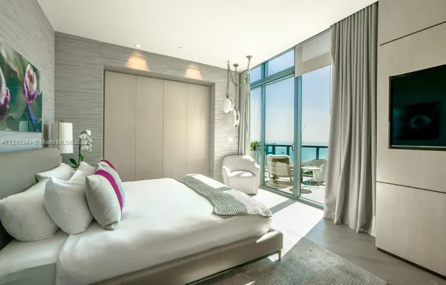 a bedroom with a large bed and a flat screen tv